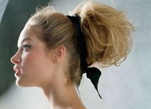 Ragazza bionda con raccolto e nastro