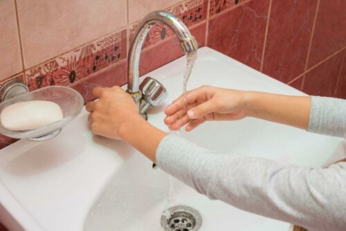 Donna si lava le mani al rubinetto