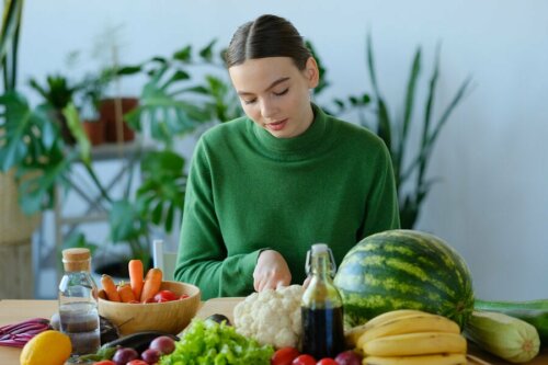 Ragazza a tavola con frutta e verdura