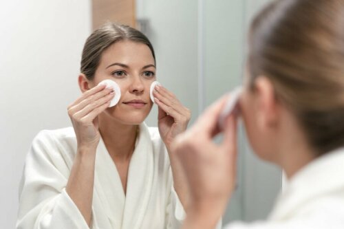 Ragazza di deterge il viso allo specchio