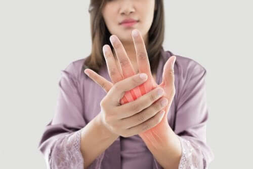 Dubbi sulla artrite e donna con mano dolorante