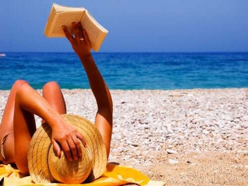 Donna in spiaggia che legge un libro