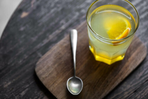 Bicchiere con acqua e limone e cucchiaino