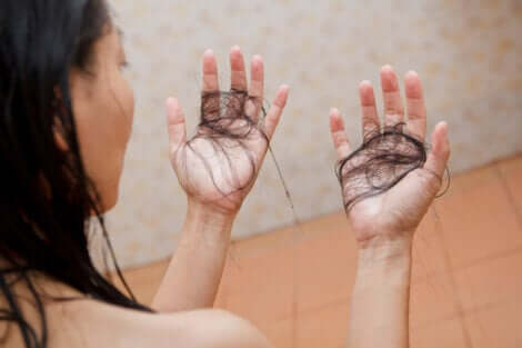 Donna con ciocche di capelli in mano.