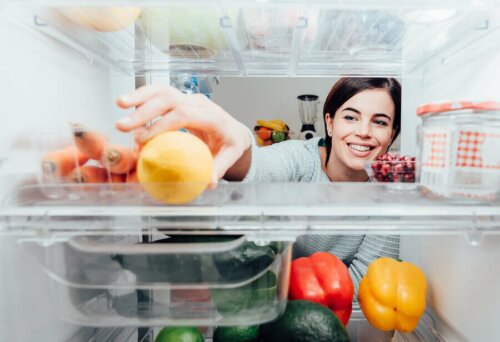 Donna prende un limone dal frigorifero