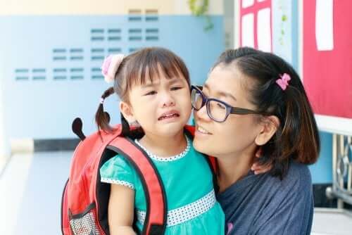 Primo giorno nella nuova scuola, mamma e figlia che piange