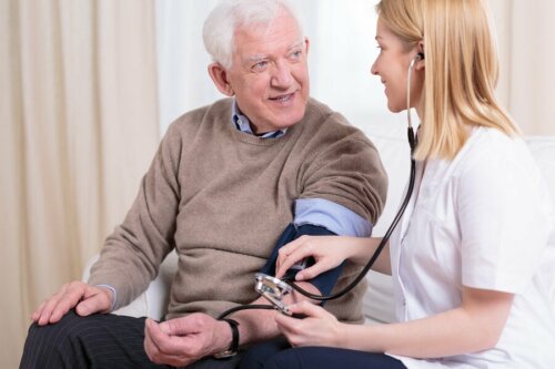 Dottoressa misura la pressione a paziente anziano