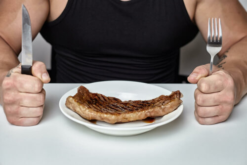 Uomo che mangia la bistecca