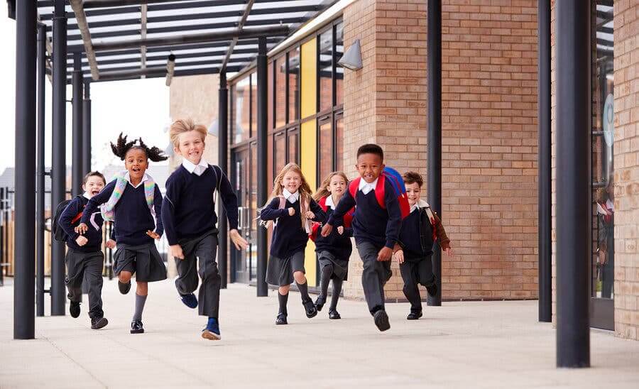 Bambini corrono all'uscita di scuola