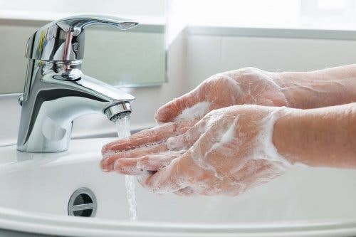 Mani insaponate sotto il getto dell'acqua