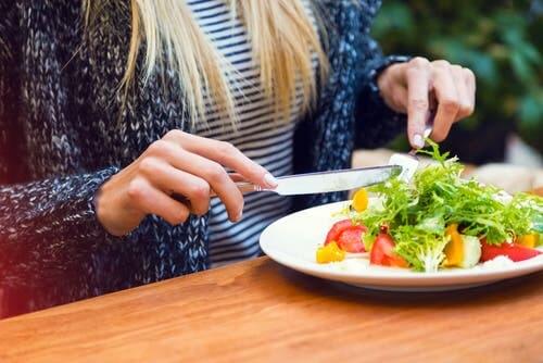 Ragazza che mangia una insalata