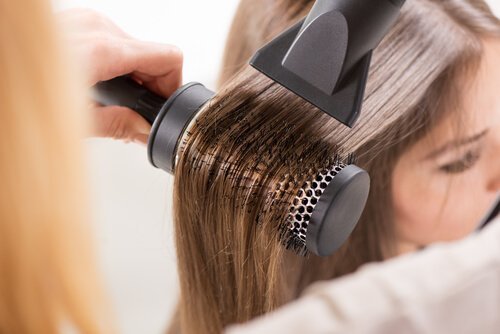 Asciugare i capelli con spazzola e phon.