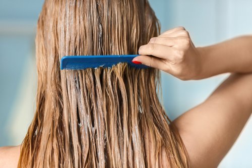 Ragazza che pettina i capelli con il balsamo.