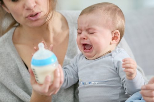 Bambino che piange col biberon