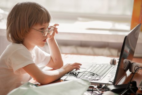 Bambino con occhiali davanti al pc