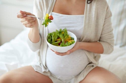 Donna incinta con ciotola di insalata