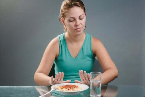 Donna che rifiuta un piatto di pasta.