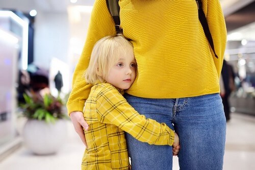 Bambina che abbraccia la mamma.