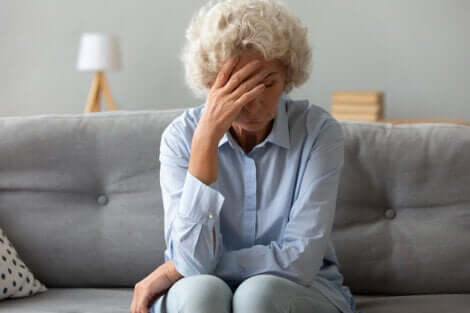 I rischi di un cancro alle ovaie aumentano nelle donne al di sopra dei 50 anni. Donna anziana preoccupata sul divano.