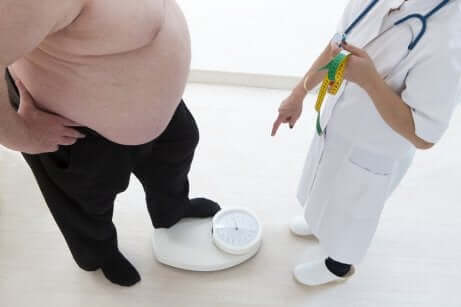 Paziente obeso sulla bilancia dal medico.