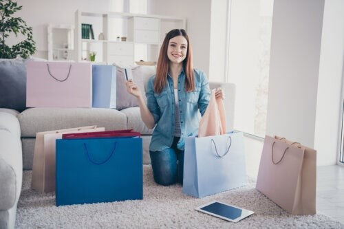 Ragazza con dipendenza da shopping e sacchetti degli acquisti.