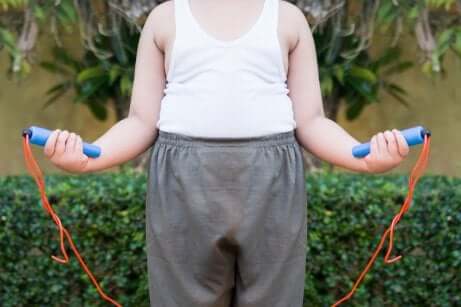 Bambino obeso che prova a saltare la corda.