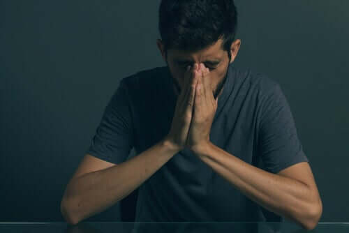 Uomo con depressione e mani giunte.