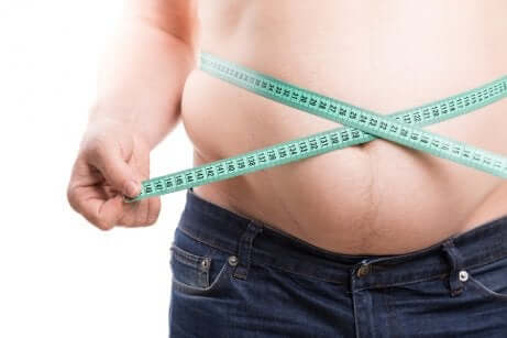 Uomo in sovrappeso misura la circonferenza addominale.
