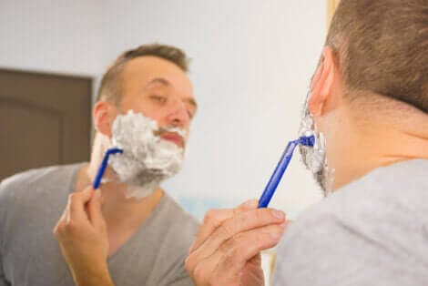 Uomo che si fa la barba davanti allo specchio.