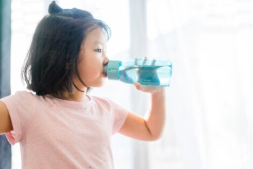 Bambina che beve acqua.