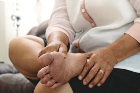 Signora si massaggia il piede diabetico.