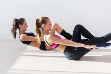 Donne sportive eseguono esercizi isometrici per gli addominali.
