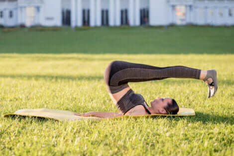 Ragazza sul prato esegue il rolling back.