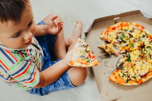 Bambino che mangia la pizza.