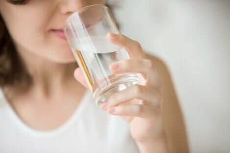 Donna con diabete insipido beve bicchiere d'acqua.