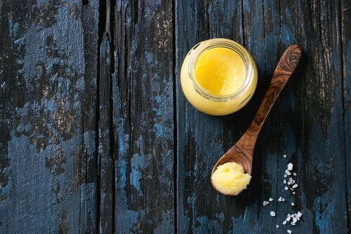 Cucchiaio e vasetto con burro chiarificato ghee.