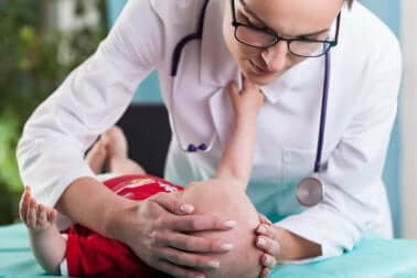 Pediatra che visita neonato.