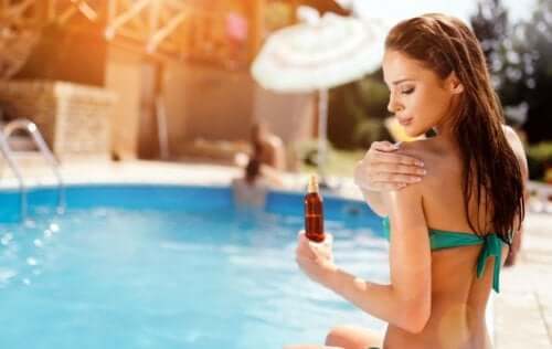 Donna che mette la crema protettiva in piscina.