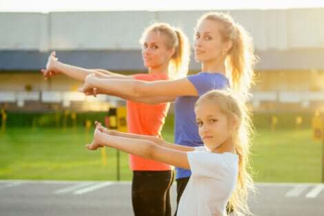 Bambina e due donne eseguono esercizi di CrossFit per i bambini.