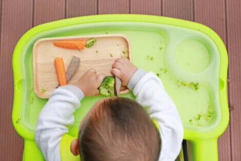Bambino che gioca con la verdura.