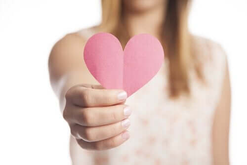 Ragazza cn cuore di carta in mano.