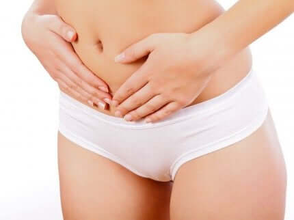 Donna con le mani sull'addome,