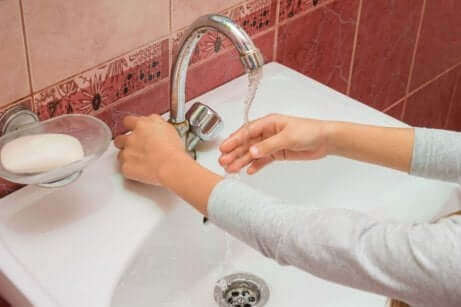 Donna si lava le mani prima di curare una ferita infetta.