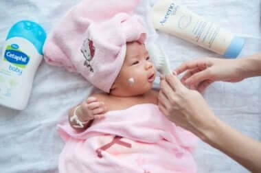 Bambina dopo doccia con crema sul viso.