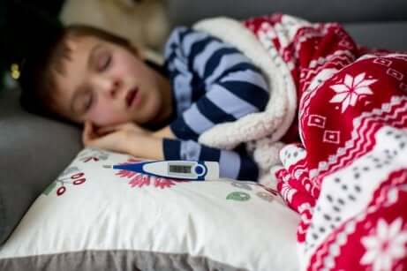 Bambino che dorme con termometro.
