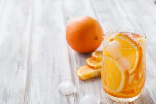 Bicchiere pieno di ghiaccio e fette di arancia.
