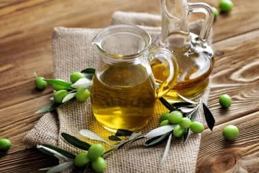 Caraffe con olio di oliva e olive verdi.