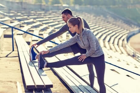 Coppia esegue lo stretching allo stadio.
