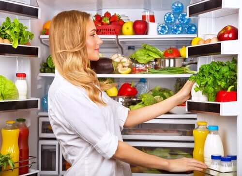 Batch cooking: donna che organizza il frigorifero.
