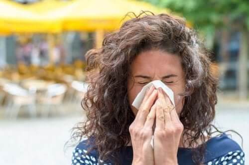 Allergia al polline: donna che si soffia il naso.